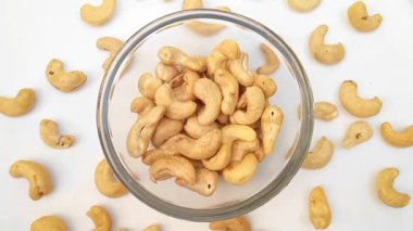 Kabuksuz kaju fıstığı beyaz arka planda cam bir kasede. Dönüyor, kapat. Kurutulmuş fındık. Çiğ çerez