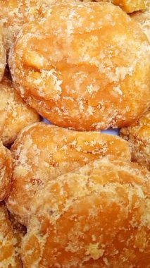 Jaggery ya da Gur parçaları arka plan dönüşümlü, üst görünüm. Organik kahverengi kamış şeker parçaları dikey olarak yakın çekim