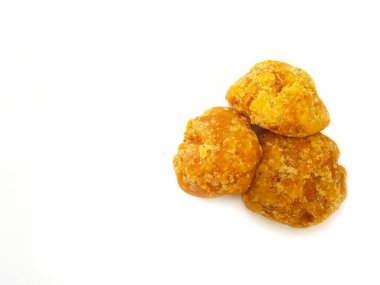 Jaggery ya da Gur 'un parçaları sağ arka planda, üst tarafta izole edilmiş. Organik kahverengi kamış şeker parçası izole edildi