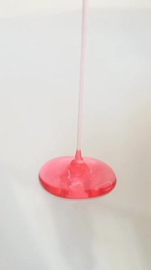 Pembe sıvı jel yüz yıkama, şampuan, temizleyici, kozmetik ya da cilt ürünleri beyaz arka planda düşüyor.