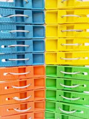 Giysi iğneleri arka plan, renkli plastik elbise askıları veya çamaşır mandalları.