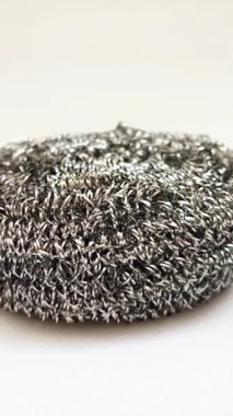 Paslanmaz çelik ovalayıcı, beyaz arka planda dönen metal tencere süngeri, bulaşık yıkamak için çelik yün temizleme yastığı, fırça tokası, dikey toka