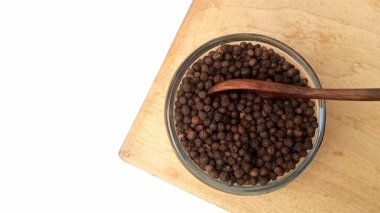 Cam kaseden ahşap kaşık, üst görüş, otlar ve baharatlarla karabiber alıyor.