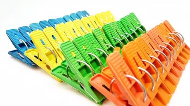 Mandal setleri, çok renkli plastik tokalar ya da beyaz arka planda dönen ev için çamaşır tokaları.