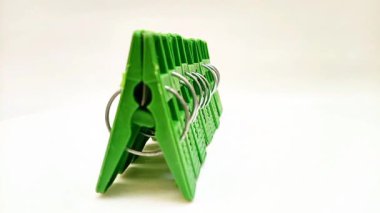 Çamaşır klipleri seti, beyaz arka planda dönen ev için yeşil plastik tokalar ya da elbise askıları.