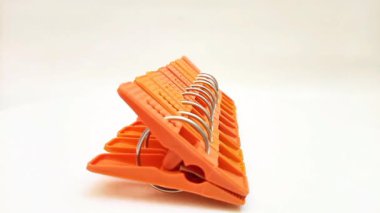 Çamaşır klipsleri seti, beyaz arka planda dönen ev için turuncu plastik broşlar veya elbise askıları.