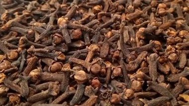 Karanfiller tam kare arka plan, mikro çekim, dönme, şifalı otlar ve baharatlar üzerine düşer.