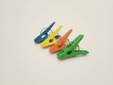 Giysi iğneleri, çok renkli plastik çamaşır tokaları ya da beyaz arka plandaki ev için elbise askıları.