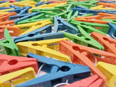 Giysi iğneleri arka plan, çok renkli plastik elbise askıları veya çamaşır mandalları ayarlar