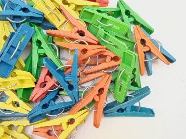 Elbise askıları, çok renkli plastik çamaşır mandalları ya da beyaz arka planda mandallar.