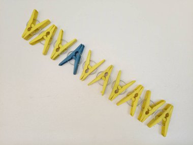 Çapraz çizgide kıyafet iğneleri, plastik çamaşır mandalları ya da elbise askıları beyaz arka planda bir çizgide.