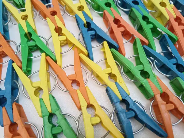 Arka planda çok renkli kıyafet broşları, renkli plastik elbise askıları veya çamaşır mandalları