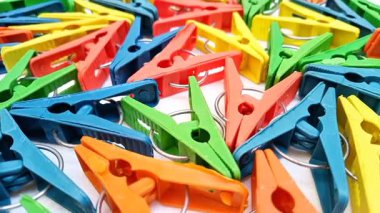 Arka planda dönen çok renkli plastik çamaşır klipleri, ev için elbise iğneleri ya da elbise askıları
