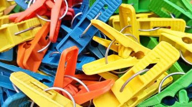 Arka planda dönen çok renkli plastik çamaşır klipsleri, ev için elbise iğneleri ya da elbise askıları, kapat