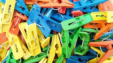 Arka planda dönen çok renkli plastik çamaşır klipsleri, mandallar ya da elbise askıları