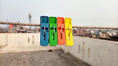 Çatı katındaki ipte asılı ev için plastik tokalar ya da elbise askıları, çamaşır tokaları, ön manzara.