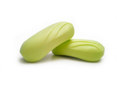 Sabun barı. Beyaz arka planda banyo yapmak için iki açık sarı sabun çubuğu. Vücut ve yüz için aromatik sabun. Sarı banyo sabunu parçaları