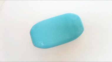 Sabun barı. Banyo için mavi sabun beyaz arka planda tek başına dönüyor. Üst Manzara. Vücut ve yüz için aromatik sabun. Mavi banyo sabunu parçaları