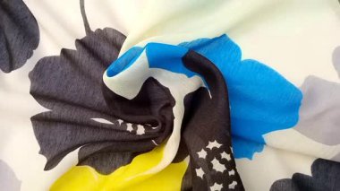 Çiçek desenli kumaş kıvrımlı, dokuma, kalın, estetik, siyah, mavi ve sarı çiçeklerle sadeleştirilmiş gri ve beyaz arkaplan