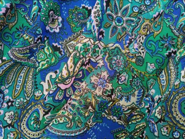 Paisley desenli kumaş katmanlı arka plan, kıvrımlı, gözyaşı damlası şekilli motifler İran kökenli mavi ve yeşil gibi canlı renklerle, desen