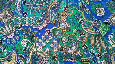 Paisley desenli kumaş detayı arka planı, kıvrımlı, gözyaşı biçimli motifler içeren İran kökenli mavi ve yeşil gibi canlı renkler, desen.