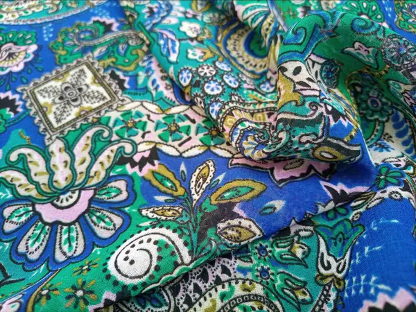 Paisley desenli kumaş detayı kıvrımlı arka plan, kıvrımlı, gözyaşı damlası şekilli motifler Pers kökenli canlı renklerle mavi ve yeşil, desen