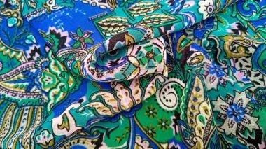 Paisley desenli kumaş detayı kıvrımlı dönen arka plan, kıvrımlı, gözyaşı damlası şekilli motifler içeren Pers kökenli canlı renkler, mavi ve yeşil, desen