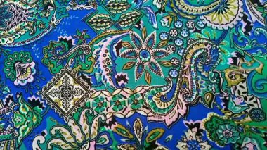 Paisley desenli kumaş detayı rüzgarla sallanıyor, kıvrımlı, gözyaşı damlası şeklindeki motifler İran kökenli, mavi ve yeşil renkli, desenli