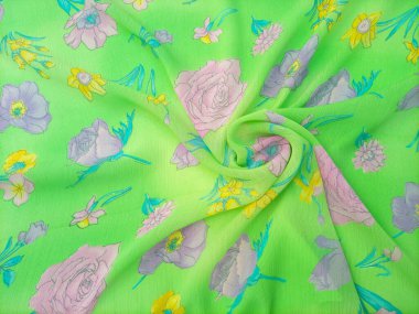 Çiçek desenli kıvrımlı güller, nergisler ve pembe, mor ve sarı tonlarında diğer çiçekler gibi çeşitli çiçekler parlak yeşil bir arkaplana saçılmıştır.