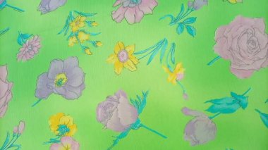 Çiçek deseninde güller, nergisler ve pembe, mor ve sarı tonlarında diğer çiçekler parlak yeşil bir arkaplanda serpilmiştir.