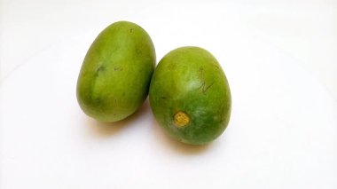 Beyaz arka planda dönen taze yeşil mango meyveleri, tropikal meyve, olgunlaşmamış mango turşusu