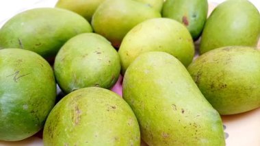 Taze yeşil mango meyveleri döner, tropik meyveler, olgunlaşmamış mangolar turşu için.