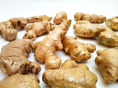 Beyaz zemin üzerinde taze zencefil kökleri veya zencefil rhizomu