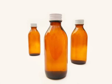 Beyaz zemin üzerinde alüminyum kapaklı kehribar cam şişeler eczacılık, şurup, gerekli yağlar ve kozmetik ürünleri için 3 kahverengi cam şişe...