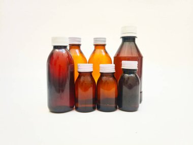 Beyaz arka planda alüminyum kapaklı farklı boyutlarda Amber cam şişeler, eczacılık, şurup, gerekli yağlar ve kozmetik ürünleri için birçok kahverengi cam şişe.,,