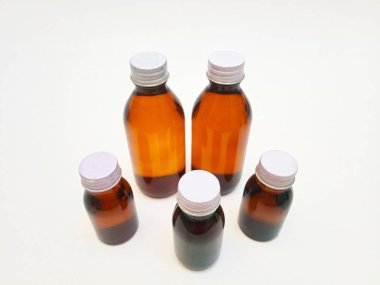 Beyaz arka planda alüminyum kapaklı farklı boyutlarda Amber cam şişeler, eczacılık, şurup, gerekli yağlar ve kozmetik ürünleri için birçok kahverengi cam şişe.,,