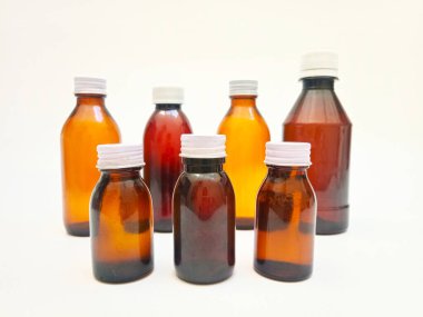 Beyaz arka planda alüminyum kapaklı farklı boyutlarda Amber cam şişeler, eczacılık, şurup, gerekli yağlar ve kozmetik ürünleri için birçok kahverengi cam şişe.,,