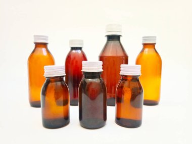 Beyaz arka planda alüminyum kapaklı farklı boyutlarda Amber cam şişeler, eczacılık, şurup, gerekli yağlar ve kozmetik ürünleri için birçok kahverengi cam şişe.,,