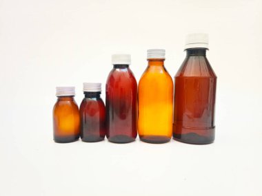 Beyaz arka planda alüminyum kapaklı farklı boyutlarda Amber cam şişeler, eczacılık, şurup, gerekli yağlar ve kozmetik ürünleri için birçok kahverengi cam şişe.,,
