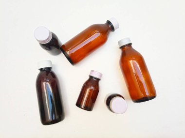 Beyaz arka planda alüminyum kapaklı farklı boyutlarda Amber cam şişeler, eczacılık, şurup, gerekli yağlar ve kozmetik ürünleri için birçok kahverengi cam şişe.,,