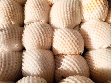 Pazarda meyve ağına sarılı taze armut yığını