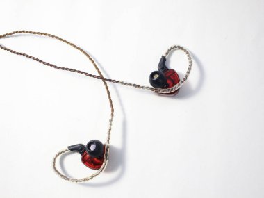 Kapalı kırmızı TWS (gerçek kablosuz stereo) kulaklıklar beyaz arkaplanda izole durumda.