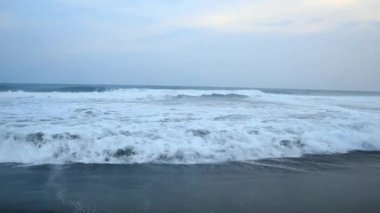 Güney Jogja Jetis Sahili 'nde sular yükseldikçe, Cornwall sakin bir gökyüzünün altında dalgalar yavaşça yuvarlanıyor, dalgalar ve köpüklerle köpürüyor..