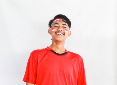 Beyaz arka planda izole edilmiş Asyalı bir adamın portresi. Erkek model Endonezya 'nın bağımsızlık günü için kutlama stüdyo fotoğraf çekiminde mutlu bir şekilde gülüyor..