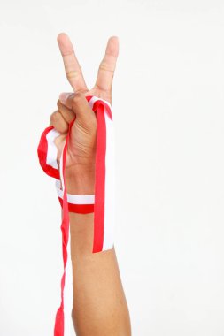 Elinde kırmızı ve beyaz bir kurdele tutan bir adam. Beyaz bir arka planda izole edilmiş, Endonezya Bağımsızlık Günü konseptini temsil ediyor. Endonezya 'nın Bağımsızlık Günü' nü kutlamak