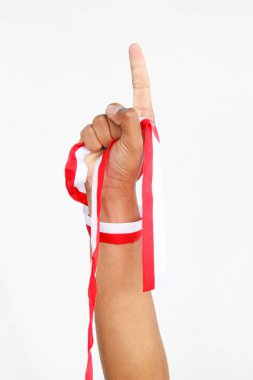 Elinde kırmızı ve beyaz bir kurdele tutan bir adam. Beyaz bir arka planda izole edilmiş, Endonezya Bağımsızlık Günü konseptini temsil ediyor. Endonezya 'nın Bağımsızlık Günü' nü kutlamak