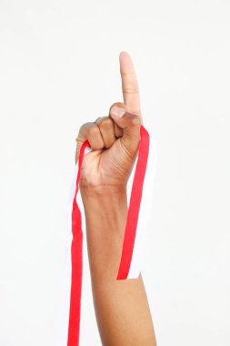 Elinde kırmızı ve beyaz bir kurdele tutan bir adam. Beyaz bir arka planda izole edilmiş, Endonezya Bağımsızlık Günü konseptini temsil ediyor. Endonezya 'nın Bağımsızlık Günü' nü kutlamak