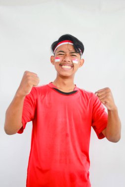 Endonezyalı adam bağımsızlık gününü heyecanlı bir ifadeyle kutluyor, Asyalı yetişkin bir adam iki elini de sıkarak haykırıyor.