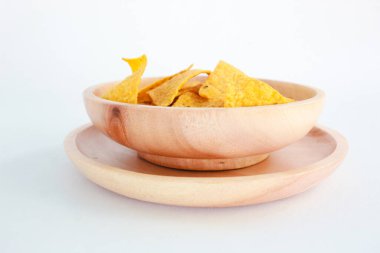 Tahta tabakta mısır cipsi, beyaz arka planda izole edilmiş. Çıtır çıtır tatlı. Gıda Fotoğrafçılığı Konsepti