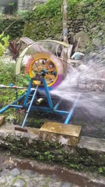 Enerji üretimi için nehir akışına monte edilmiş su tekerleği, makaralar veya kısa video içeriği oluşturmak için uygundur